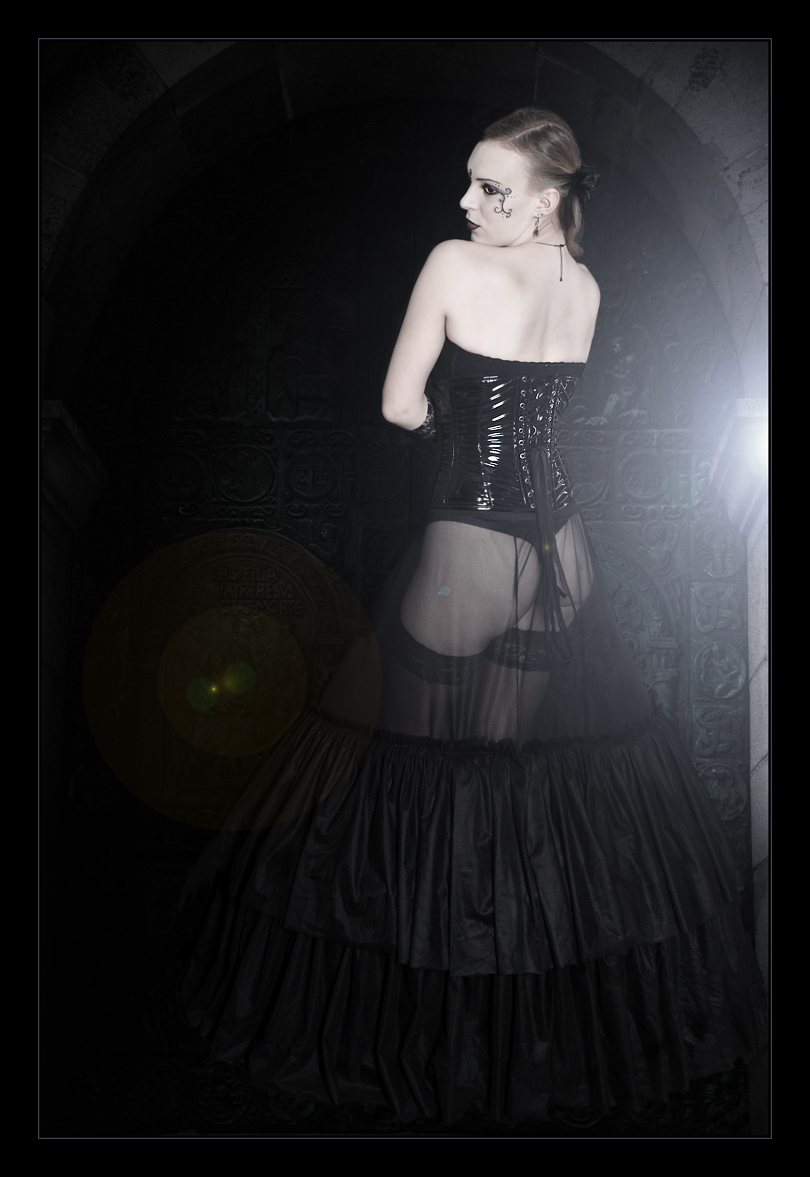 Gothic Beauty - Sexy Photo of a gothic style model with black corsage and a transparent skirt showing her bum posing in front of a black gate - Photo © by Magistus