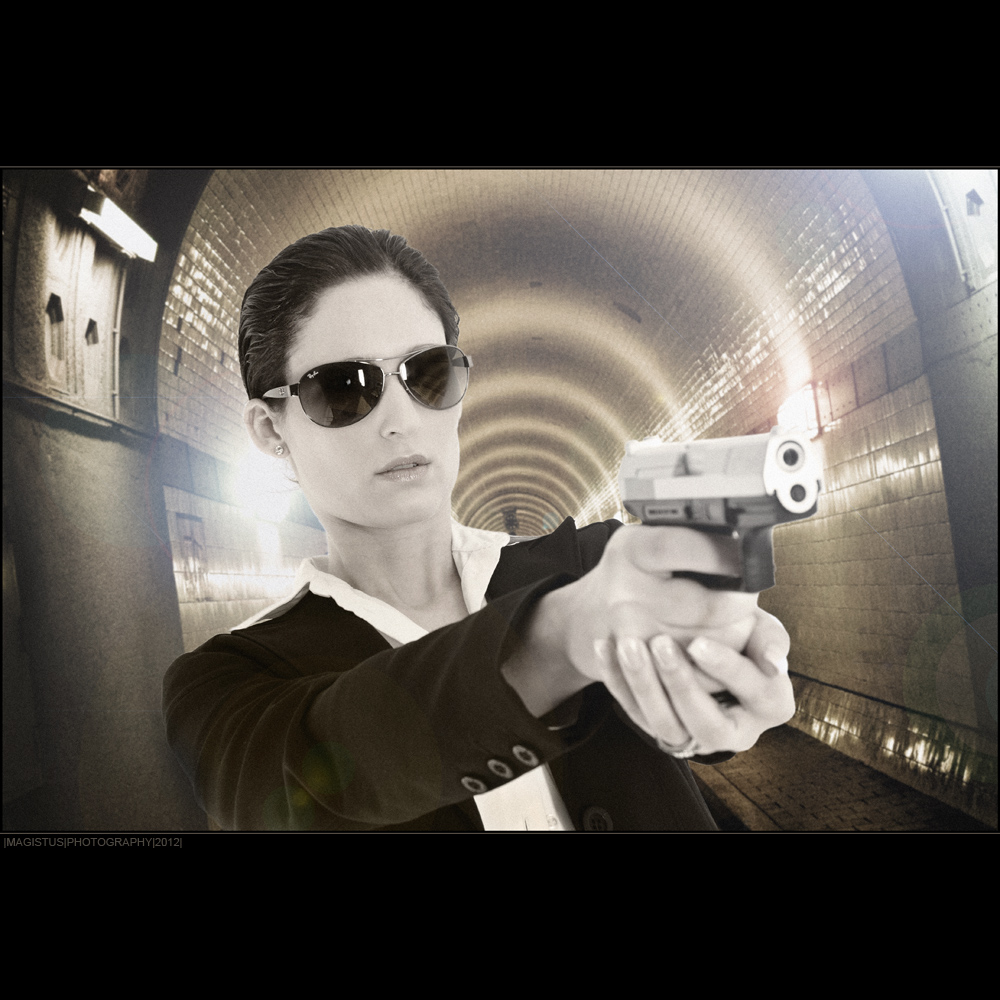 Detective - Agent-Composing with cool and beautiful model wearing sunglasses holding gun in her hands standing in a long tunnel - Photo © by Magistus