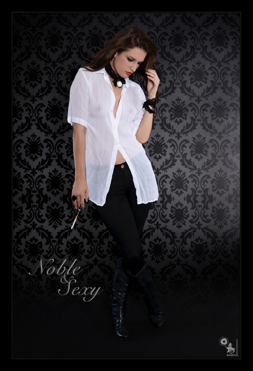 Noble & Sexy - Fashion Shooting with beautiful model posing in front of a black wall wearing black jeans and a white, transparent top showing of the shadows of her nipples and boobs. A sexy, hot and beautiful portrait! - Artwork © by Magistus - Background © by Thomas Leonhardy - Fotolia.com