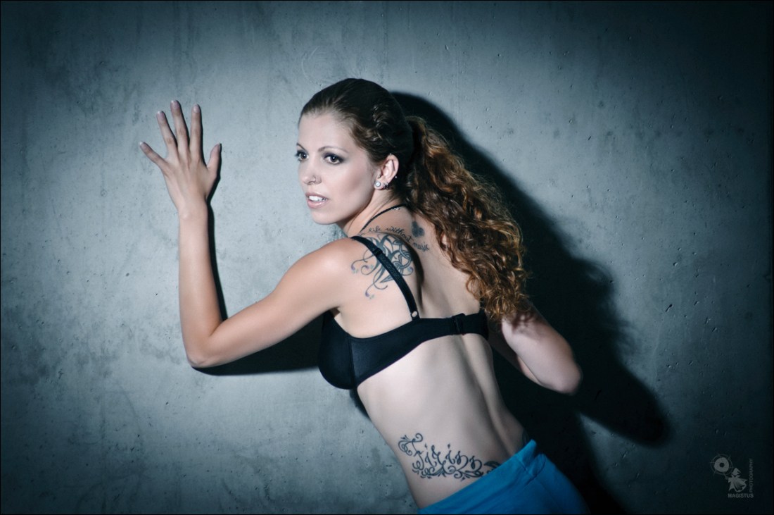 Beauty Shadows - OnLocation Photoshoot with fantastic long haired model posing in front of a wall with a black bra and long shadows - © by Magistus