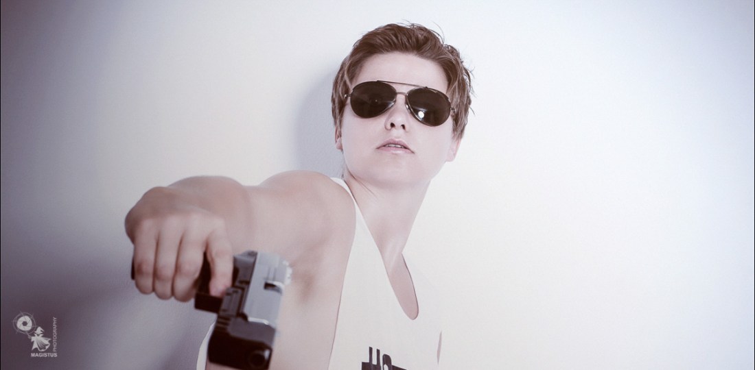 Sexy Shooter - Studio Portrait Photoshoot with busty model posing with a gun showing some sideboob - © by MagistusFoto