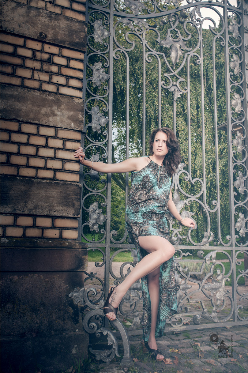 Summer Fashion posing in front of a fantastic metal gate showing a lot of her awesom long legs. - Fantastic Model on Location - © by MagistusFoto
