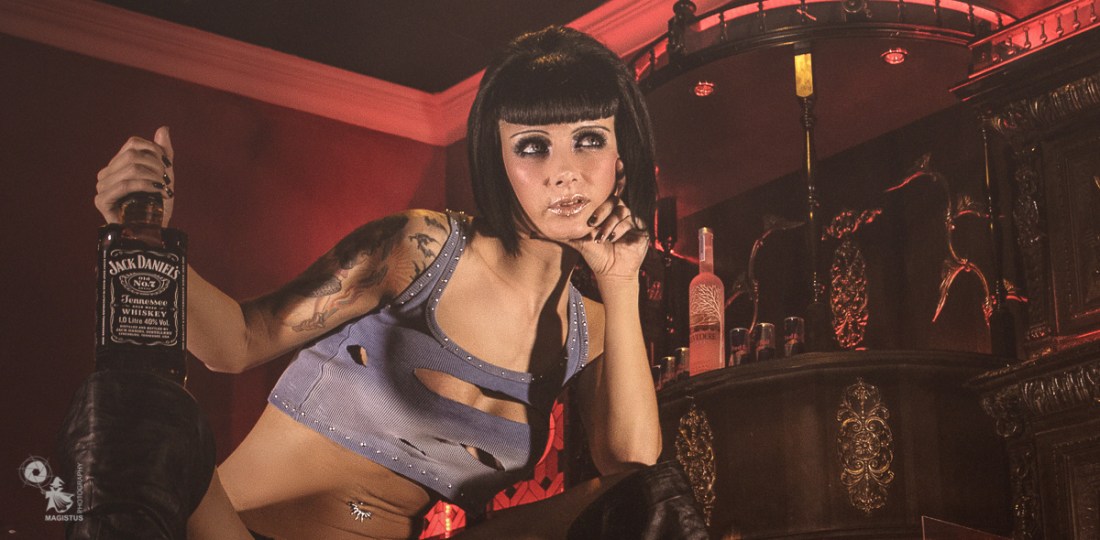 Sexy Barkeeper - Erotic OnLocation Photoshoot with fantastic big busted model posing hot with a bottle of whisky - © by Magistus