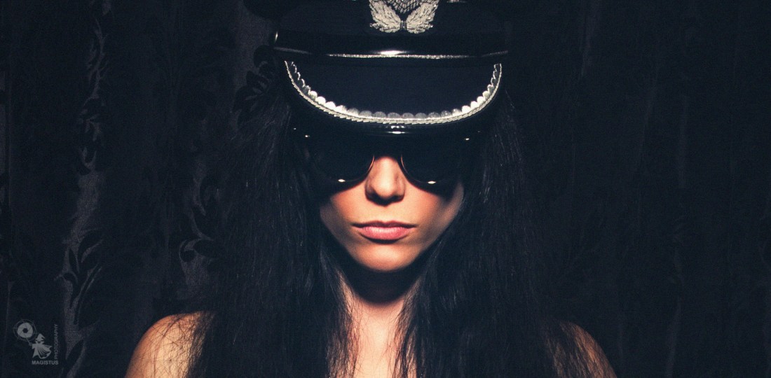 Fetish Fashion - Fantastic fetish model is posing cool in a black corsage with sunglasses and a german airforce officers cap. - © by Magistus