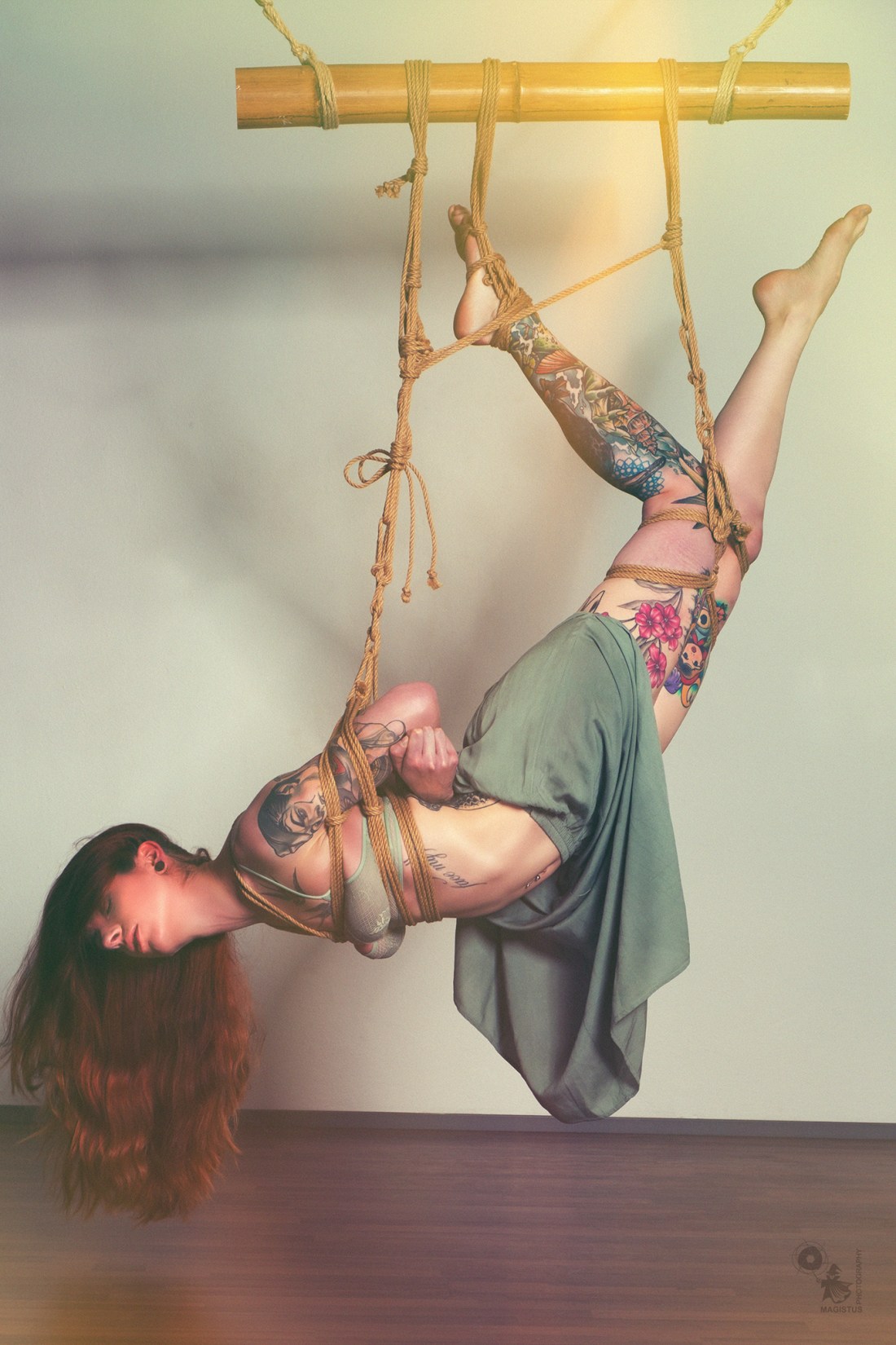 Flying - fantastic shibari photo with great tattooed model hanging in tight bondage wearing lingerie - © by Magistus - ropework by Hr. Pieps